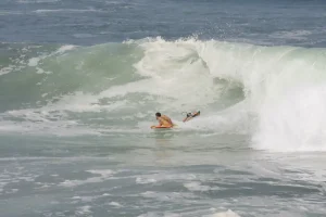 hombre haciendo bodyboard en una ola